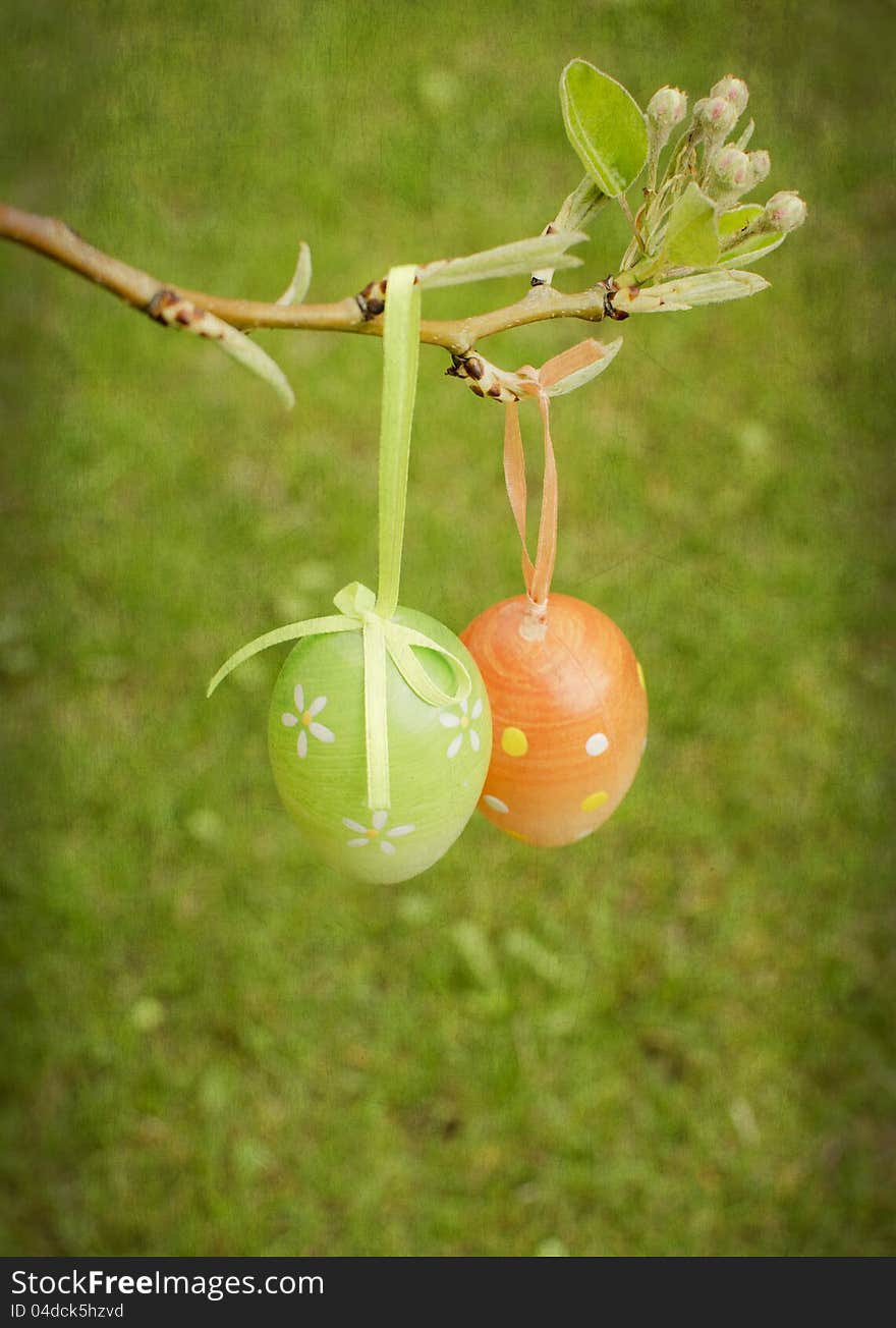 Decorative Easter eggs on a pear branch with green background