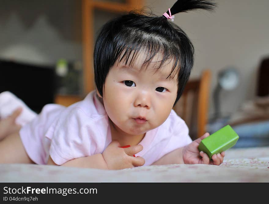 A 12 months chinese Baby girl Pull a face on the bed