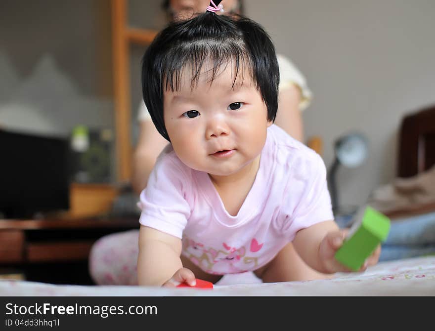 A 12 months chinese Baby girl Pull a face on the bed