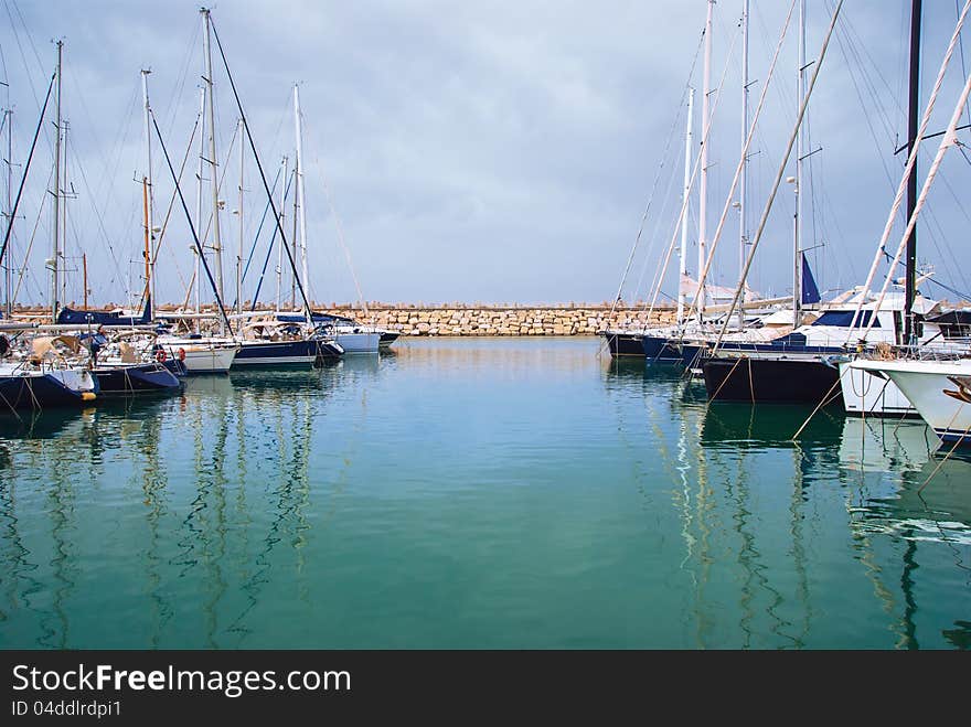 Yachts in the harbor standing on an anchor,  against the blue sky