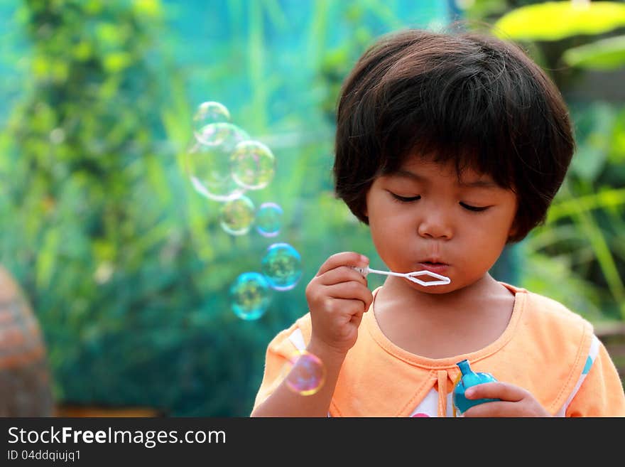 Thai little girl blowing bubbles