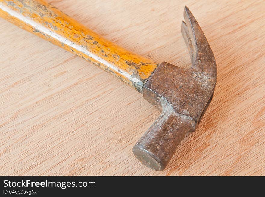 Old hammer on wood background