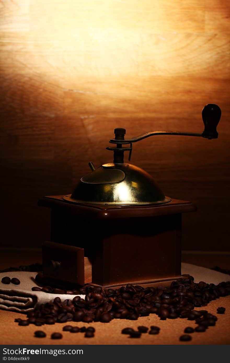 Old coffee grinder on wooden background