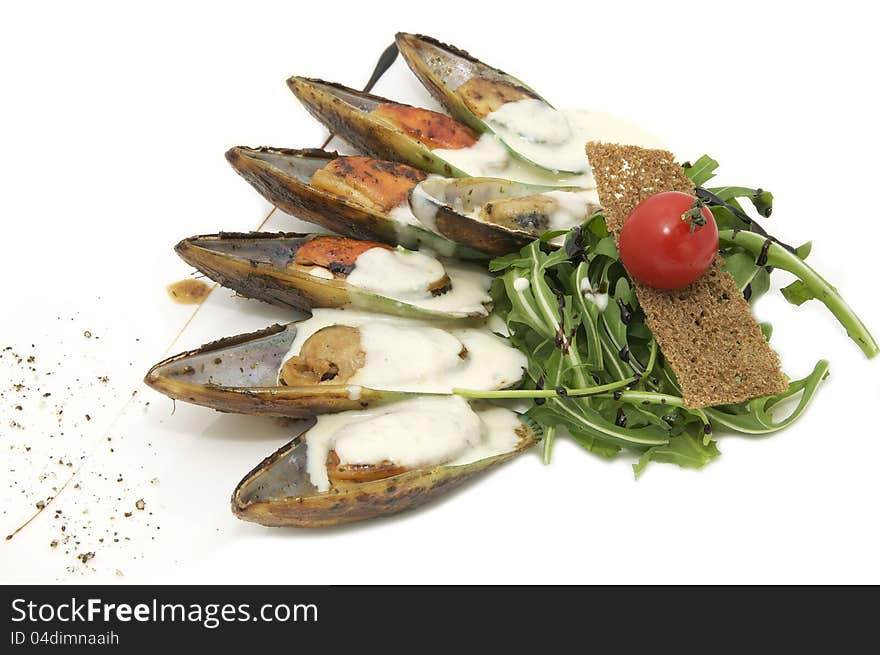 Mussels with sauce and greens on a white background