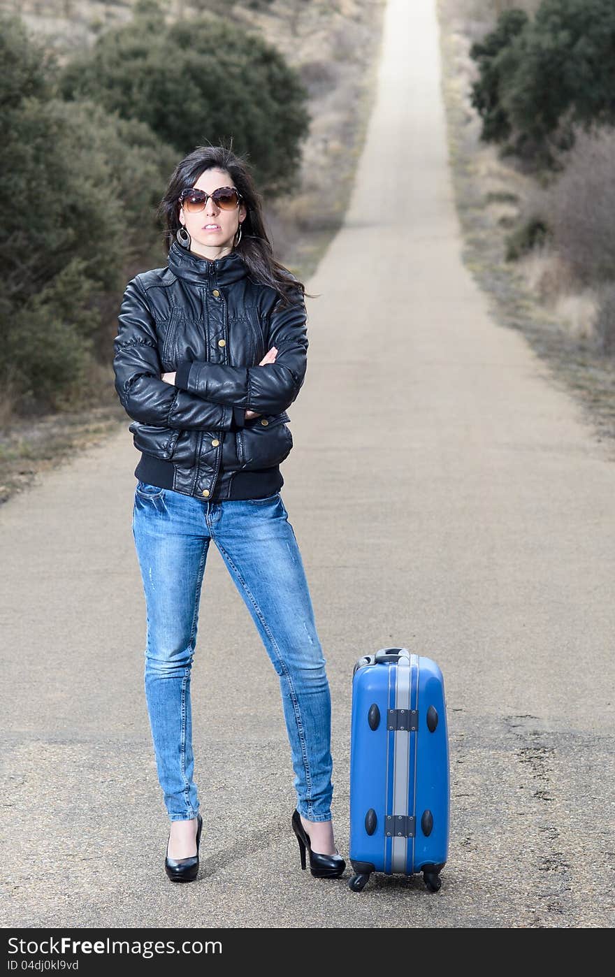 Woman In Lonely Road With Suitcase