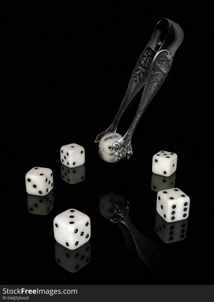 Dice and ancient silver nippers on a black background. Dice and ancient silver nippers on a black background.