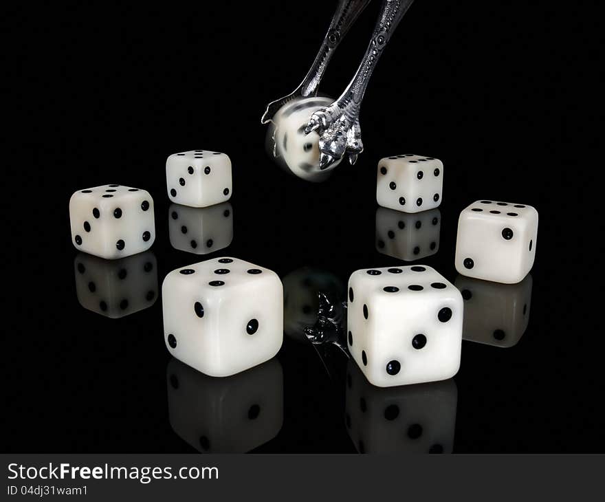 Dice and ancient silver nippers on a black background. Dice and ancient silver nippers on a black background.