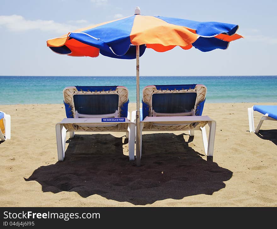 Beach umbrella and deckchairs