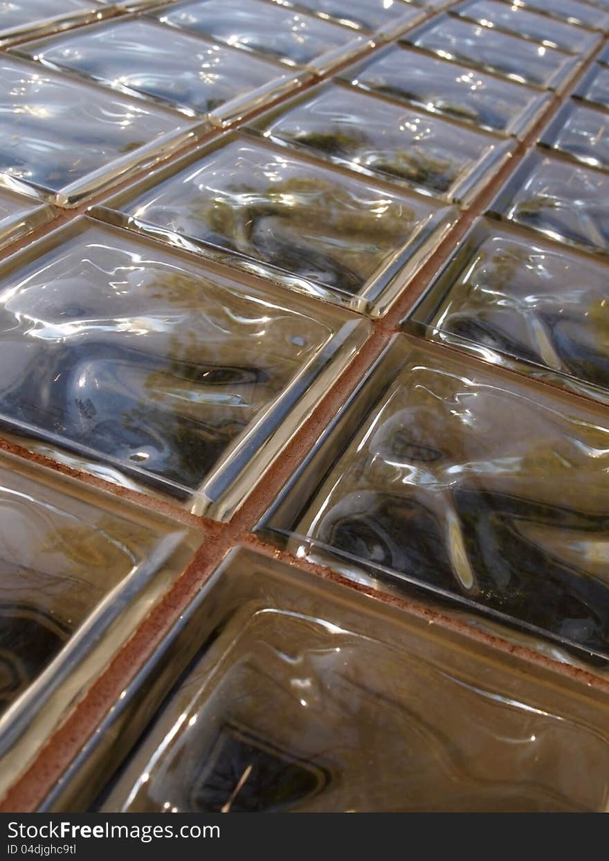 Background image featuring an outdoor wall of glass blocks in the sunlight. Background image featuring an outdoor wall of glass blocks in the sunlight.