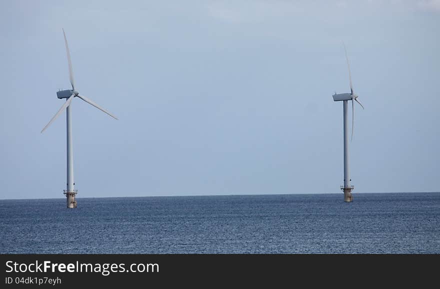 Two Wind Turbine Towers Standing in the Sea. Two Wind Turbine Towers Standing in the Sea.