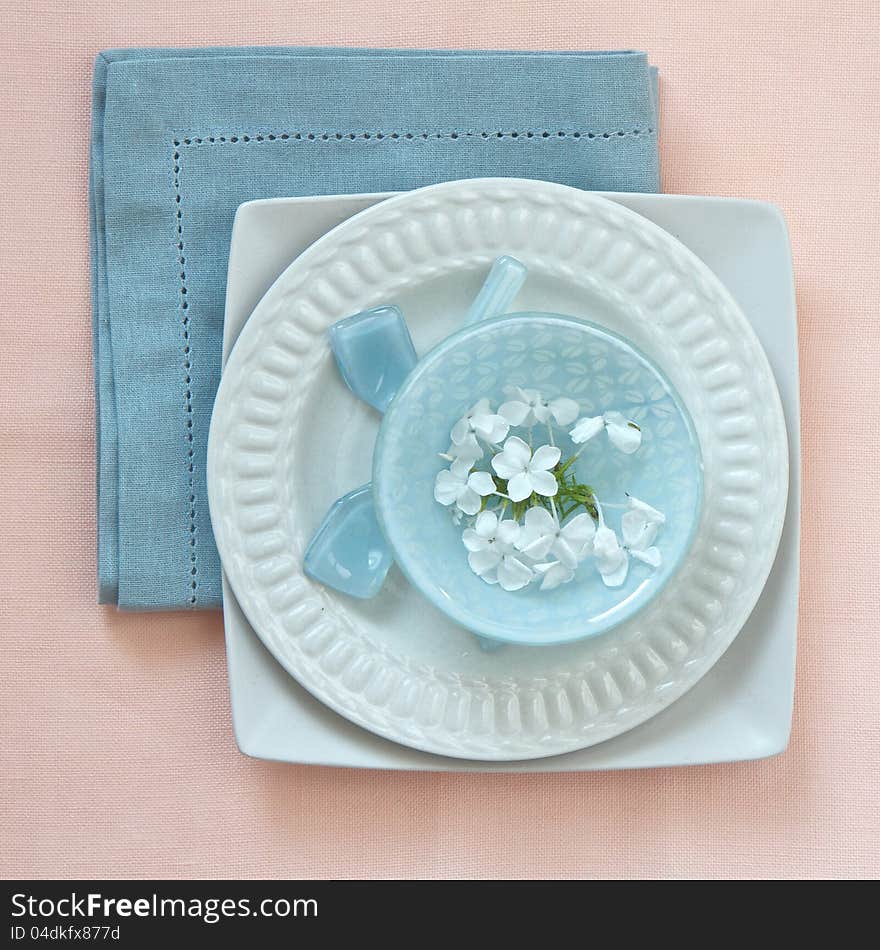 Table place setting in pink and blue with flowers