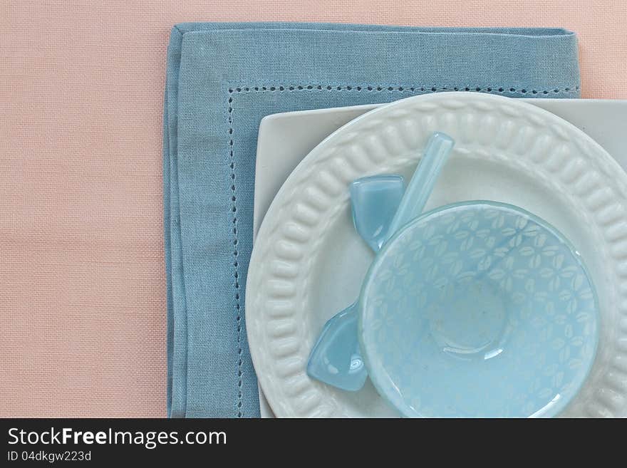 Table place setting in blue and pink with white crockery