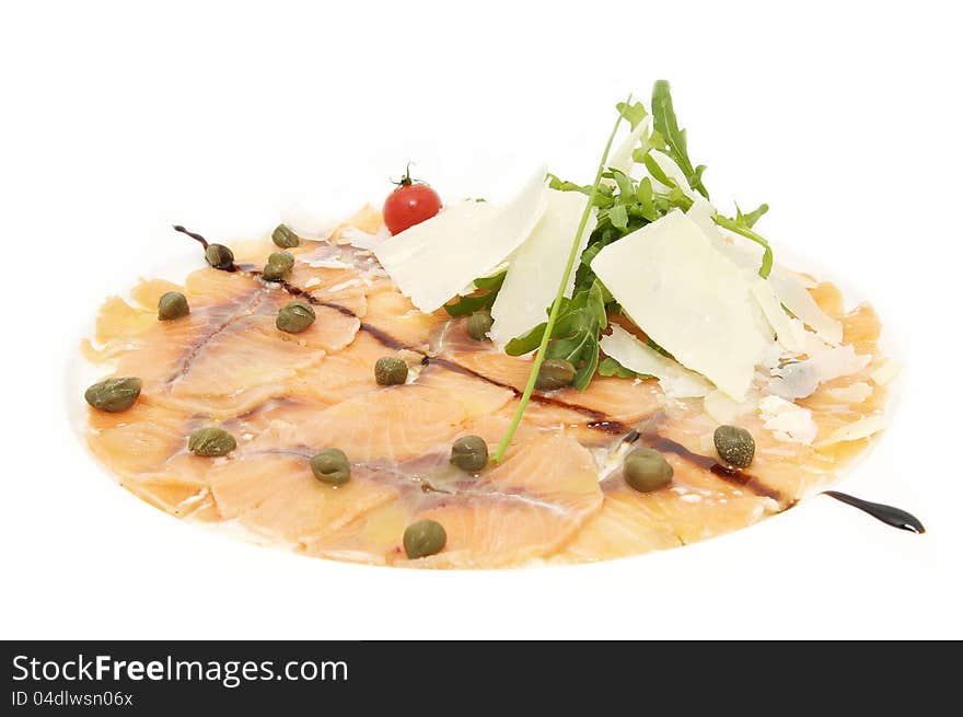 Fish carpaccio with cheese and herbs on a white plate