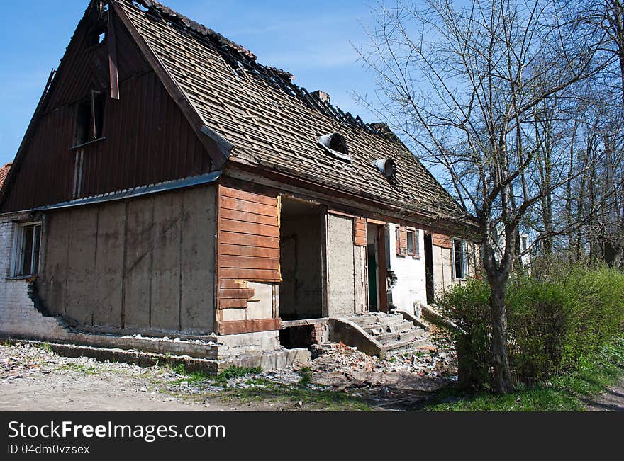 Old broken house in the street on sunny spring day