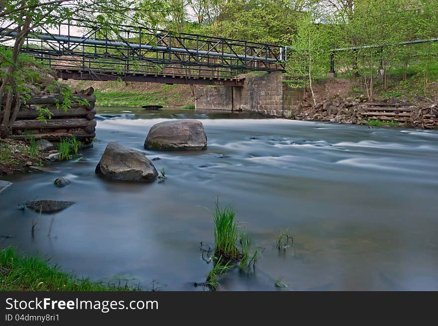 River landscape with the bridge stones and an old timbered felling