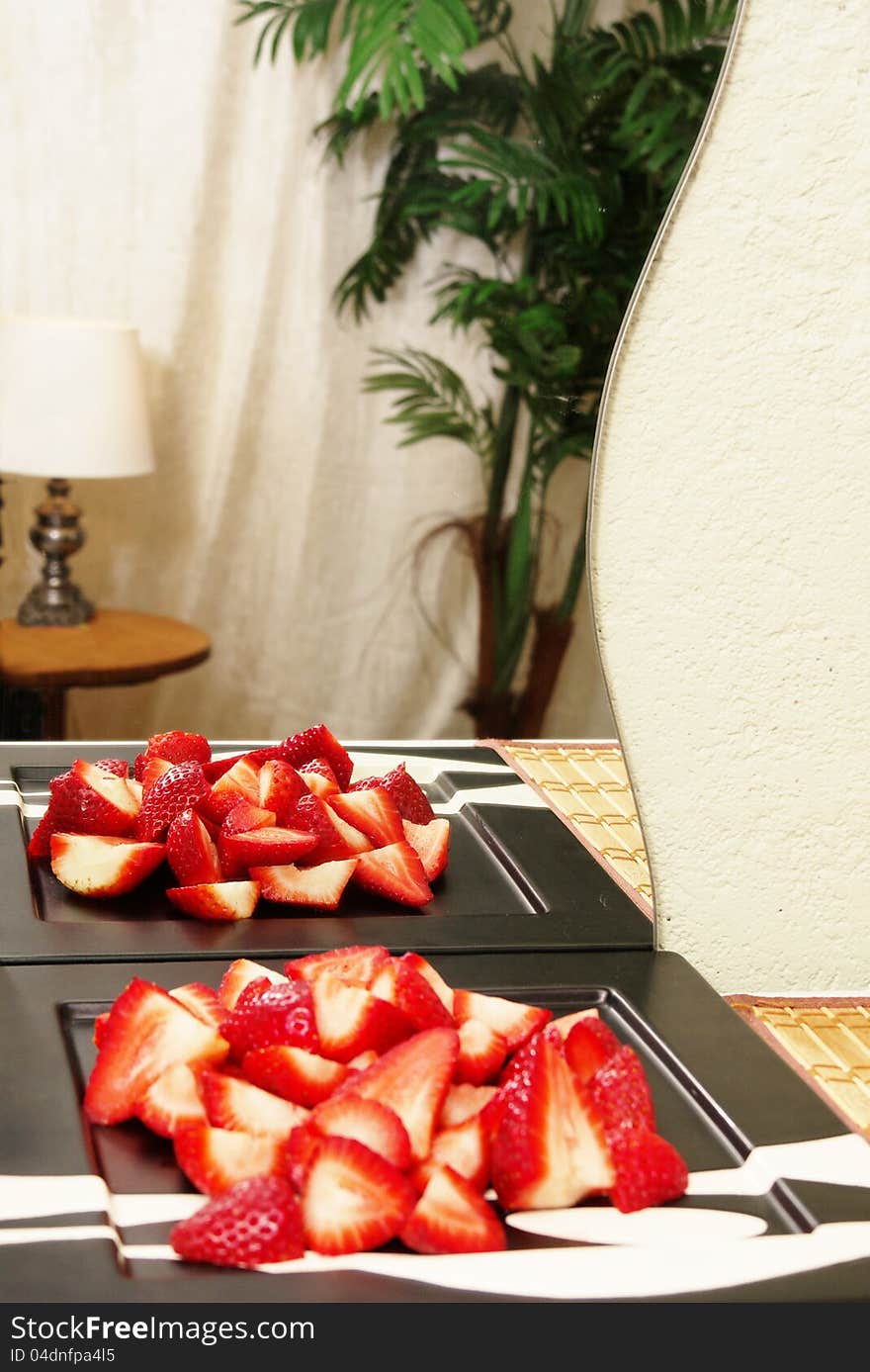 Sliced Strawberries reflected in hotel room mirror on bamboo mat. Sliced Strawberries reflected in hotel room mirror on bamboo mat.