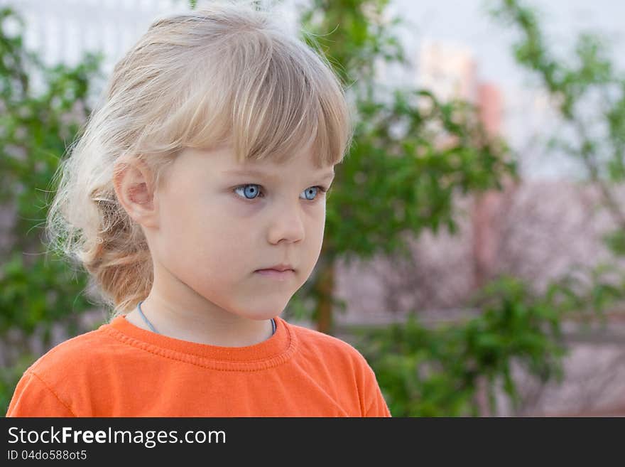 Thoughtful blue-eyed girl in orange t-shirt. Thoughtful blue-eyed girl in orange t-shirt