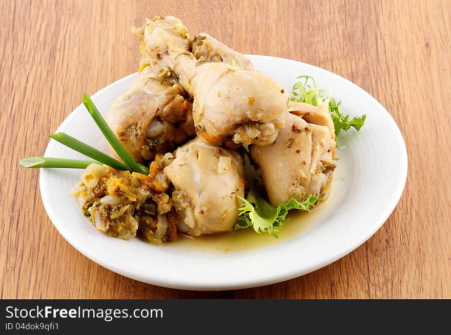 Roasted chicken legs vegetables saute and greens close up on wooden background