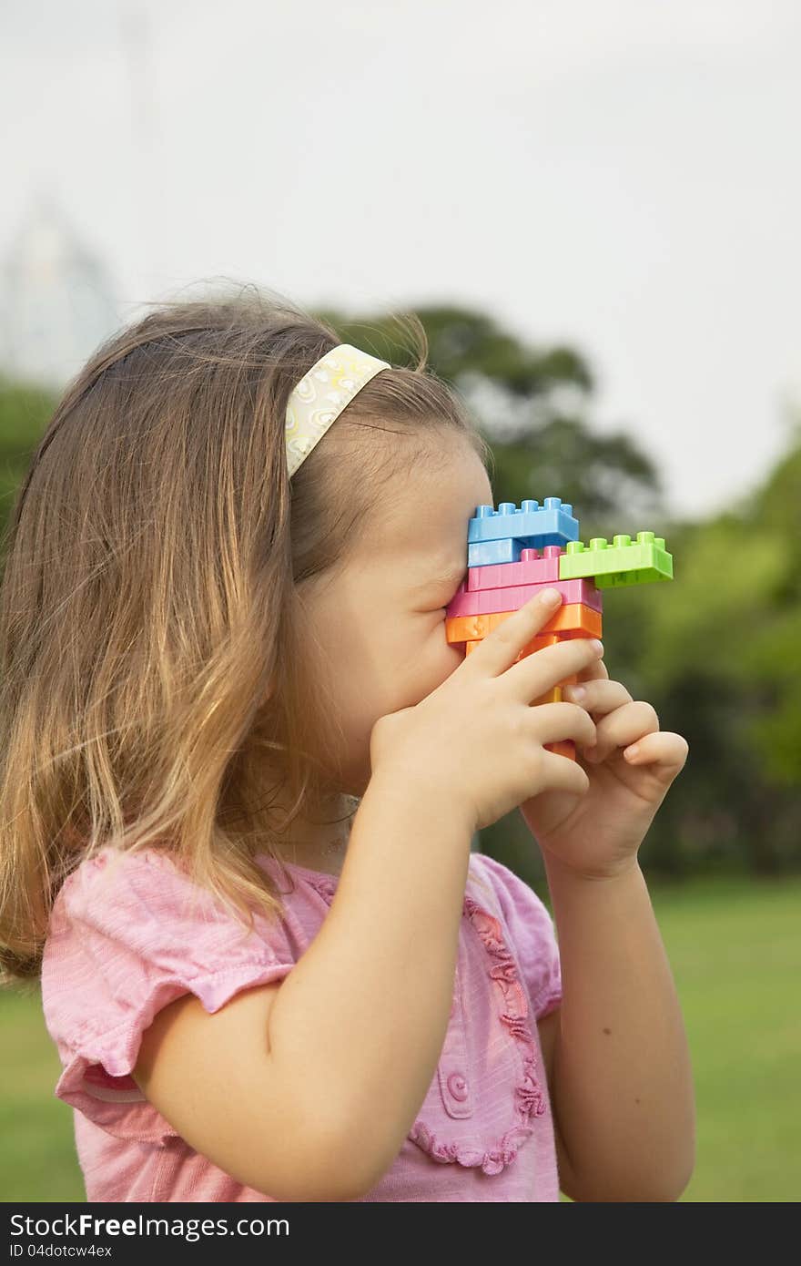 Portrait of a girl playing outdoors in the constructor. Portrait of a girl playing outdoors in the constructor