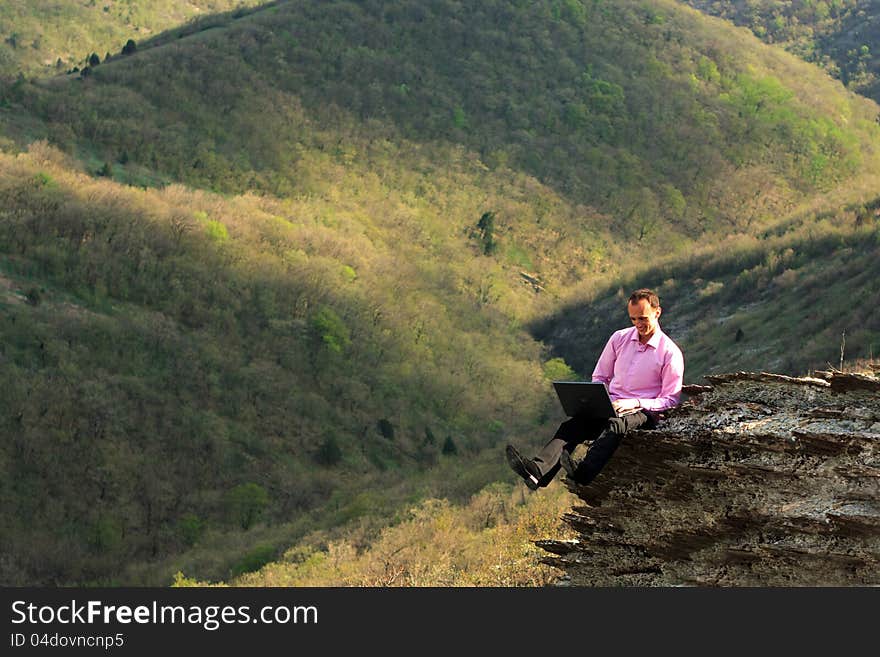 Man With Computer On Stone