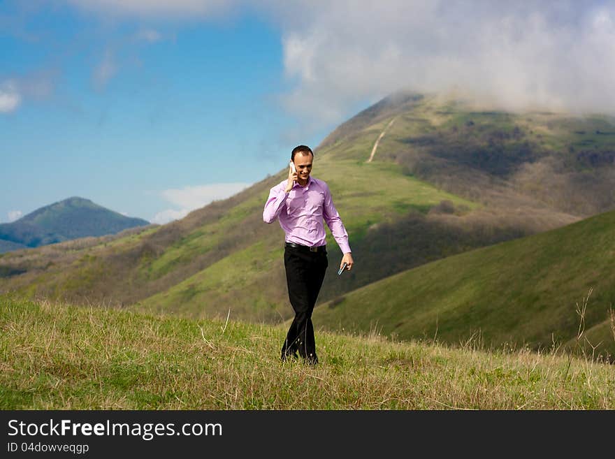 Man in mountain talks the telephone on subject of the business. Man in mountain talks the telephone on subject of the business