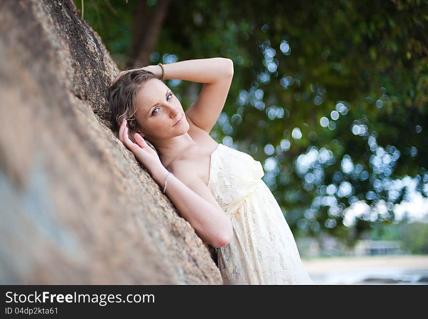 A beautiful young girl in white dress resting in s