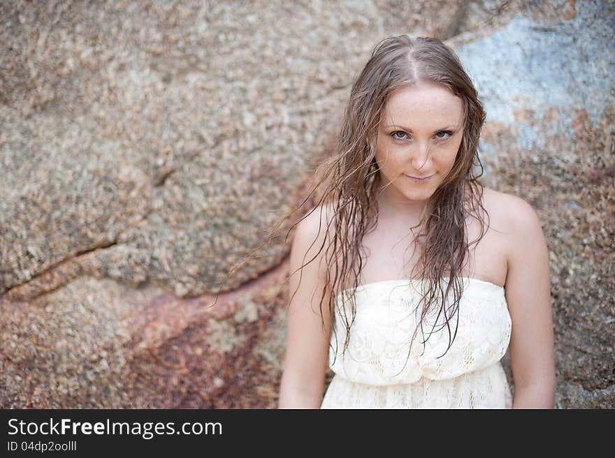 A beautiful young girl in a white dress with a sto