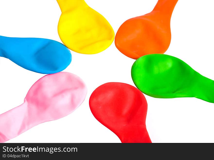 A set of rainbow-colored uninflated balloons laid down star-shaped (isolated on white). A set of rainbow-colored uninflated balloons laid down star-shaped (isolated on white)