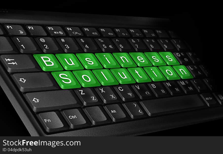 Laptop keyboard and text ''Business solution'' colored green.