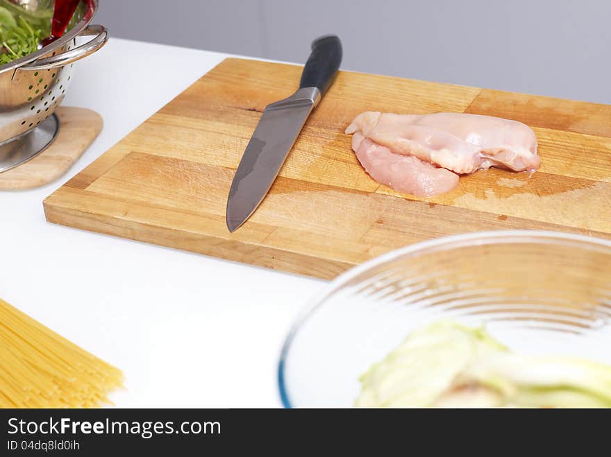 Chicken slice stacked on a board standing on table. Chicken slice stacked on a board standing on table