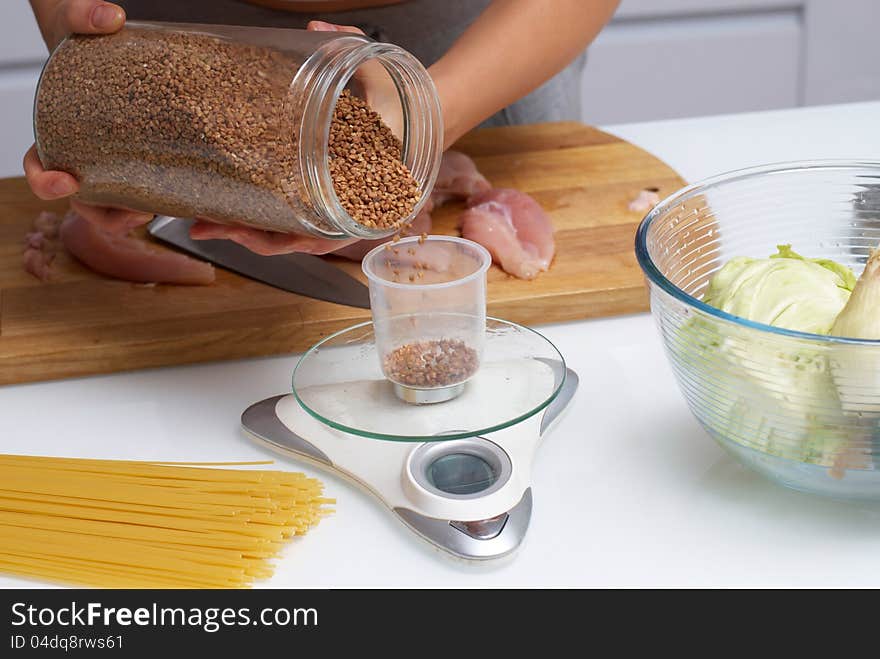 Female hands pouring buckwheat from pot