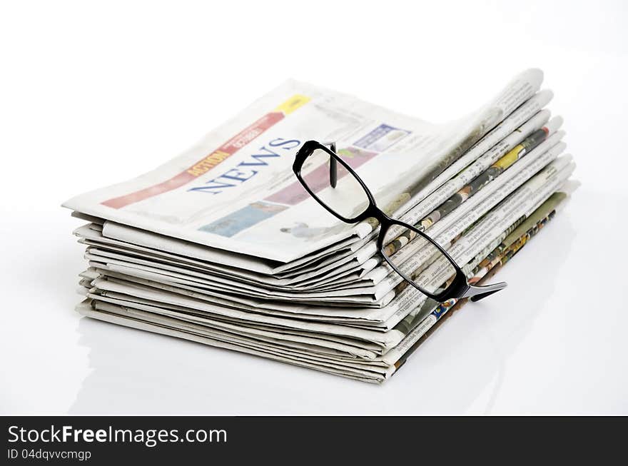 Bird eye view of glasses on newspapers against white background. Bird eye view of glasses on newspapers against white background