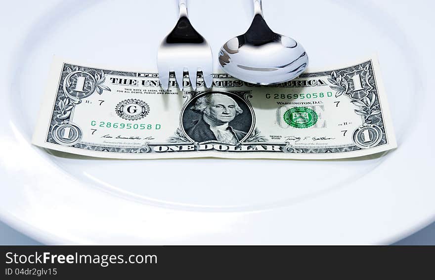 Spoon and fork on money in the plate