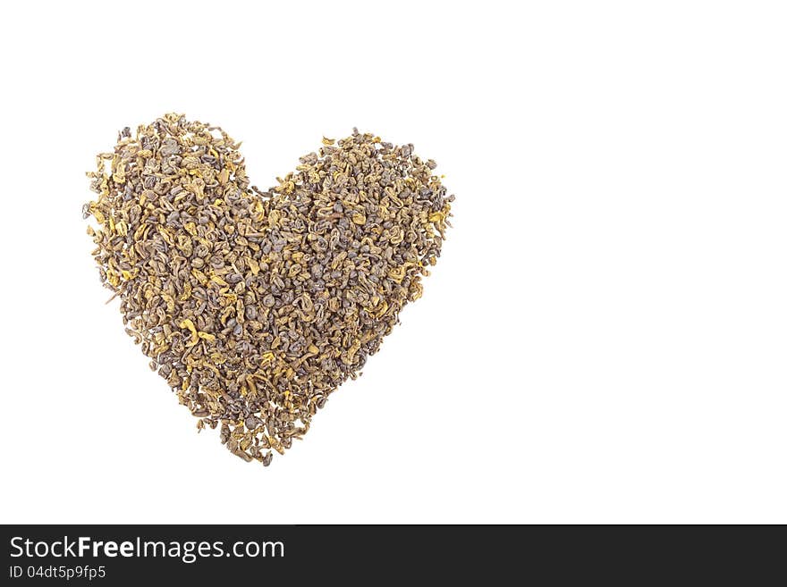 Green tea dried leaves shaped in a heart on a wooden desk. Green tea dried leaves shaped in a heart on a wooden desk.