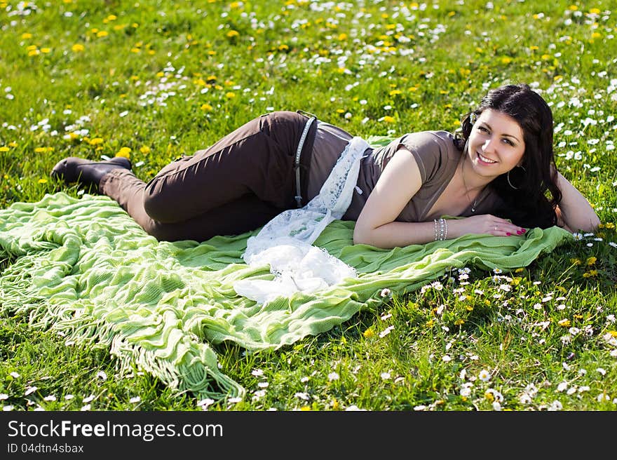 Beautiful girl lying on the grass with flowers