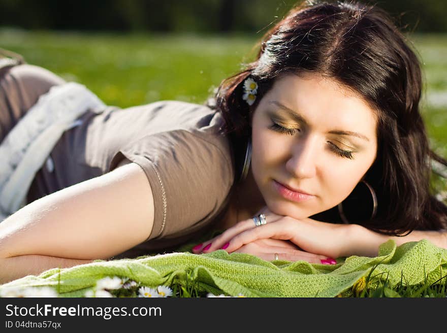 Beautiful girl lying on the plaid in the park