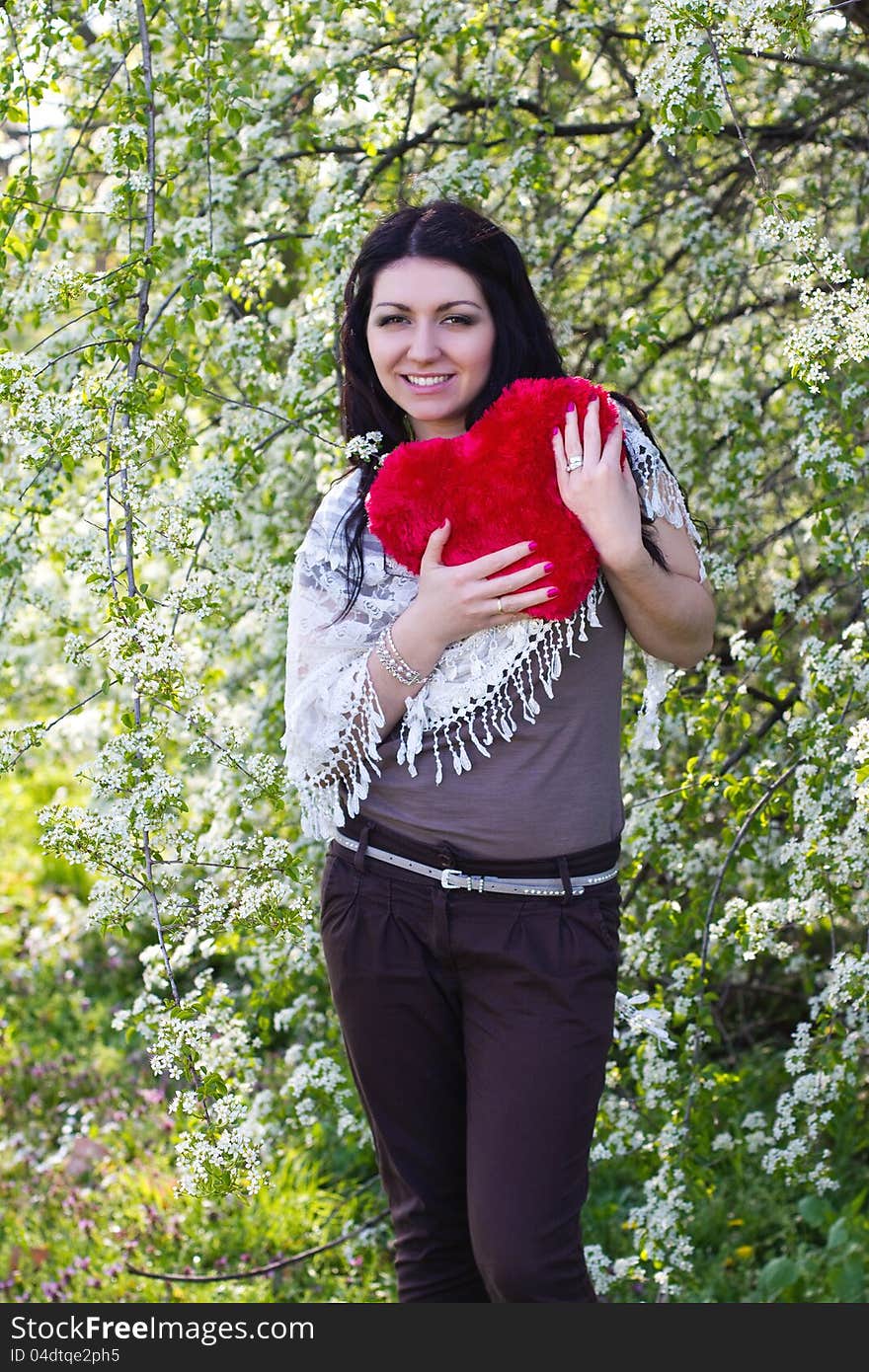 Happy young woman holding red heart. Happy young woman holding red heart