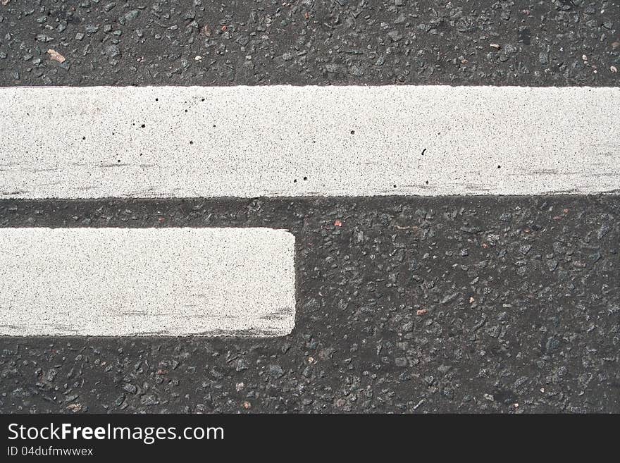 Road asphalt with white markings. The texture of the background. Road asphalt with white markings. The texture of the background