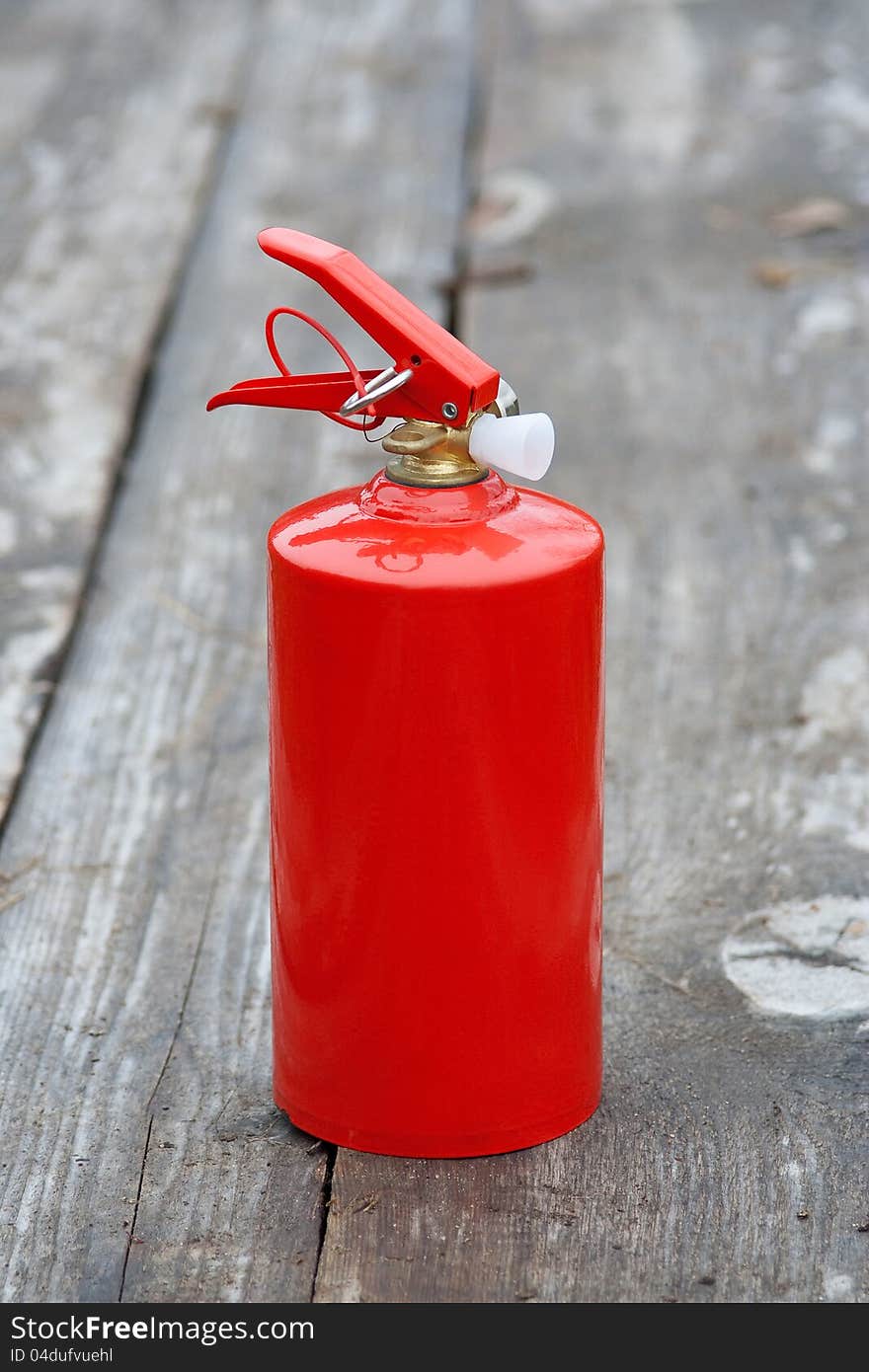 Extinguisher On The Wooden Sidewalk