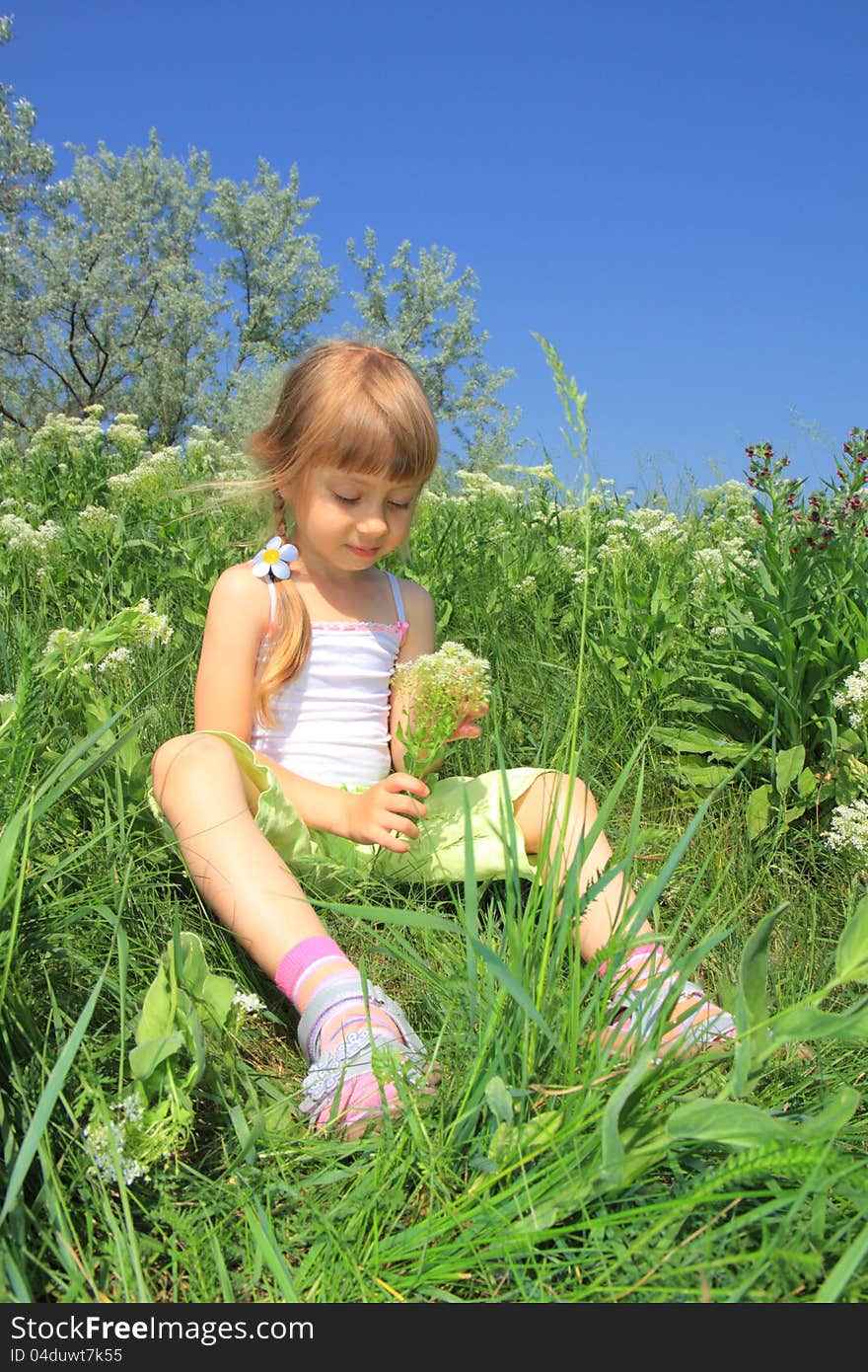 Little Girl Sits In The Grass