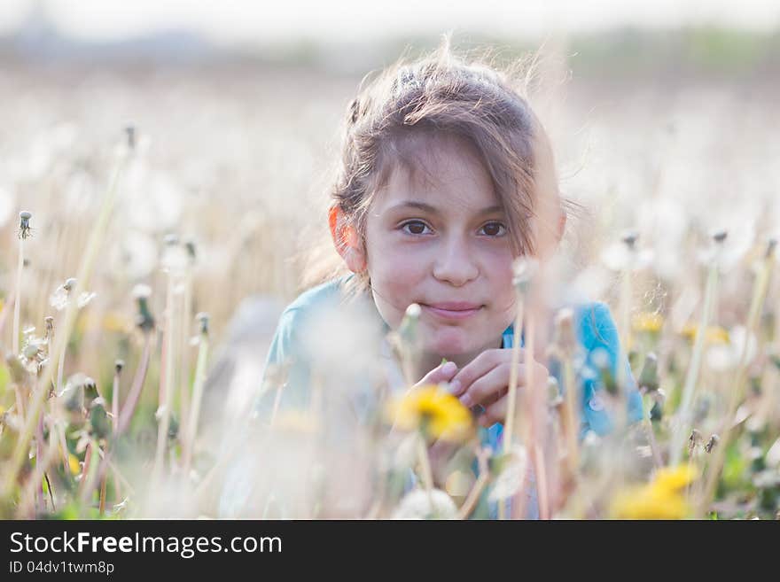 Beautiful girl in a dandelion meadow