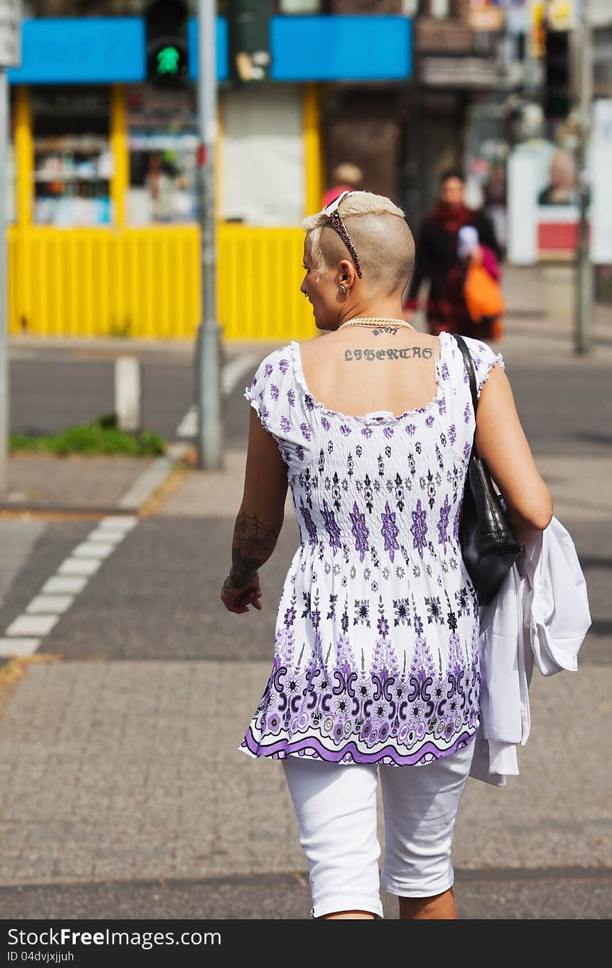 Tattooed woman crossing a road