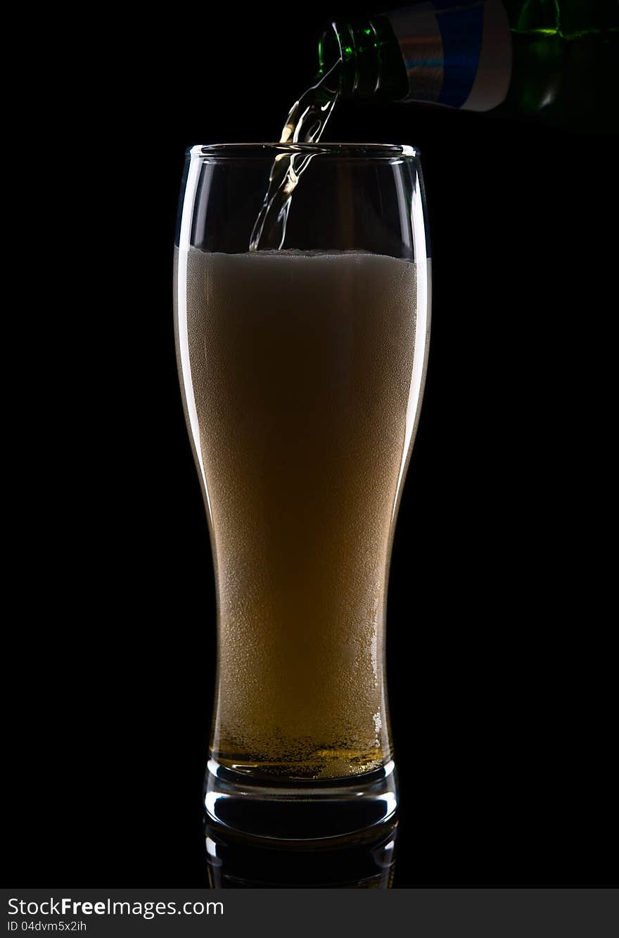 Fresh beer with froth and condensed water pearls on black  background. Fresh beer with froth and condensed water pearls on black  background