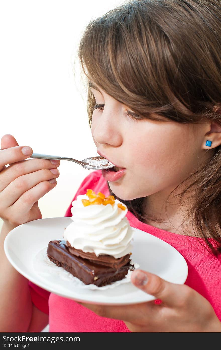 Fun teen girl eating the cake on the white background .Portrait of young woman eating cake isolated on white background