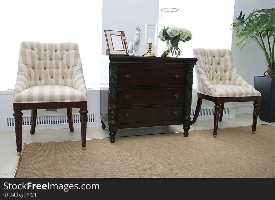 Comfortable upholstered chairs and a coffee table with books