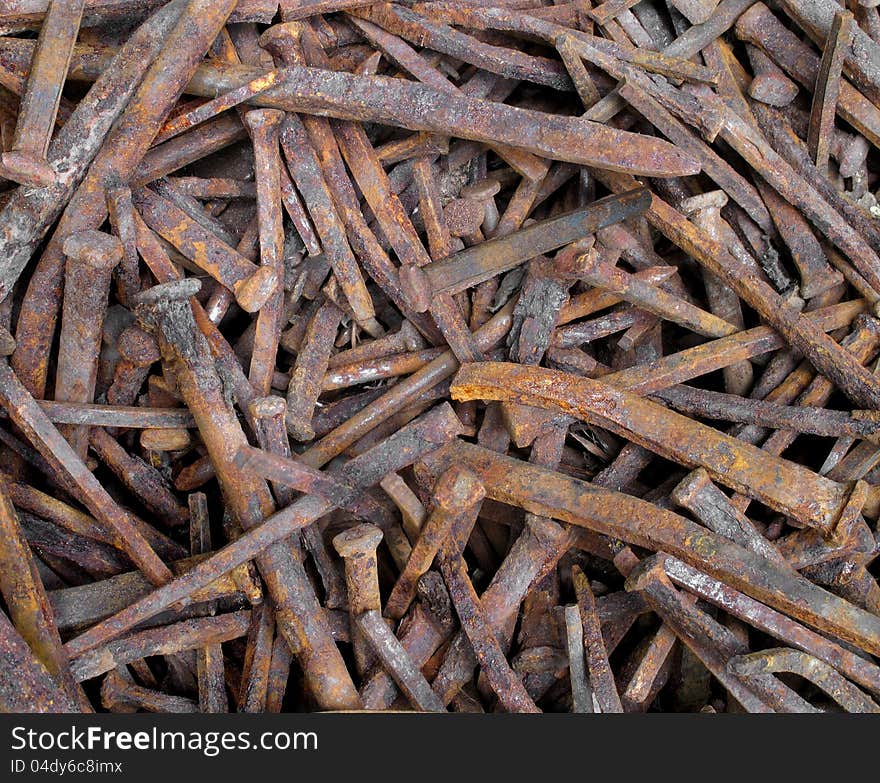 Close-up of a pile of old rusty square nails. Suitable for a background.