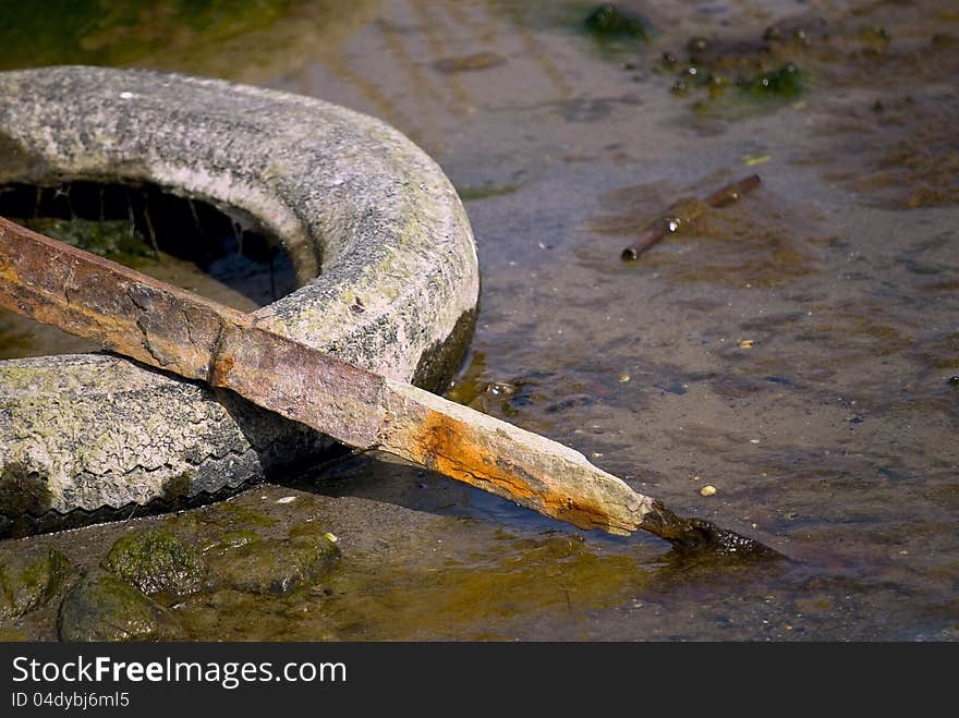 Debris in the form of old car tires and scrap metal in nature. Debris in the form of old car tires and scrap metal in nature