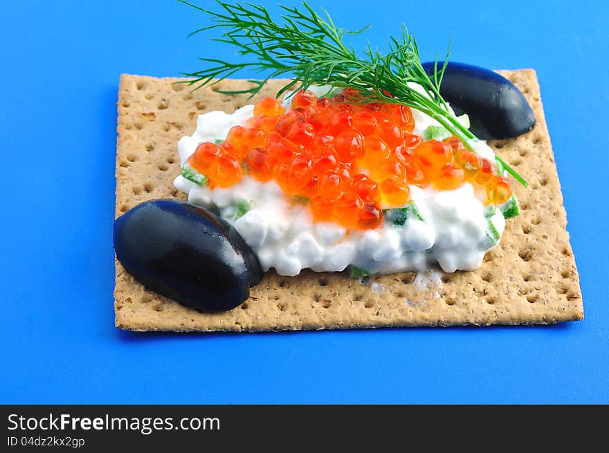 Crackers with cheese, caviar, a sprig of fennel and black olive. Crackers with cheese, caviar, a sprig of fennel and black olive