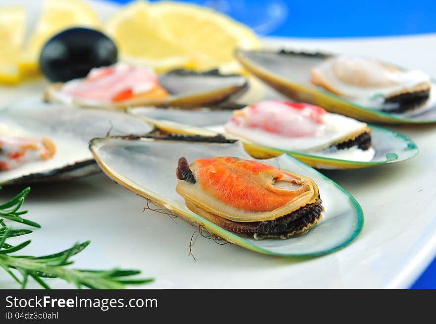 Mussels in white sauce with lemon and olives, the sharpness of the front shell