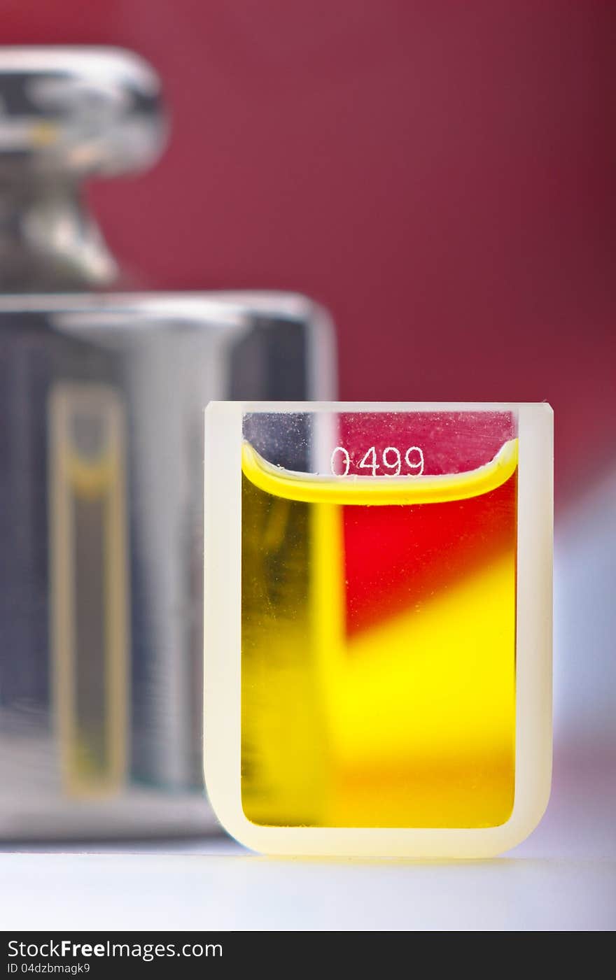 Yellow sample of a liquid in small glass container with the volume level described. Yellow sample of a liquid in small glass container with the volume level described